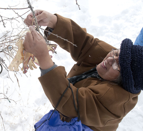 Patty Timbimboo-Madsen ties an offering to her ancestors onto a tree during the 150th anniversary memorial ceremony of the Bear River Massacre, Tuesday, Jan. 29, 2013 near Preston, Idaho. (Eli Lucero/Herald Journal)